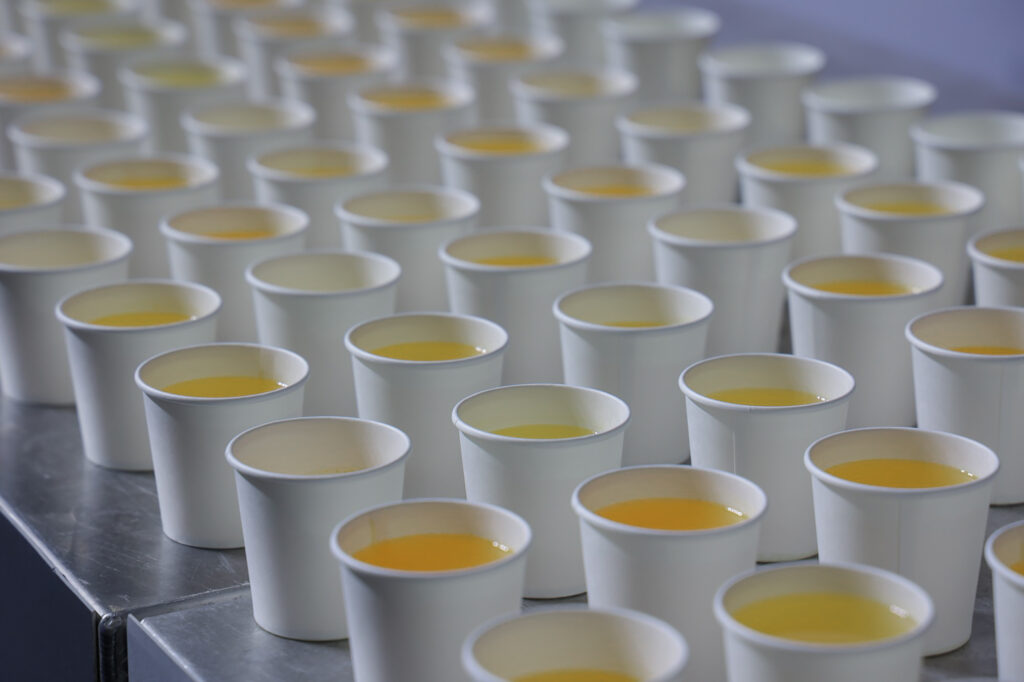 Rows of hydration cups prepared for athletes at a HYROX race station.