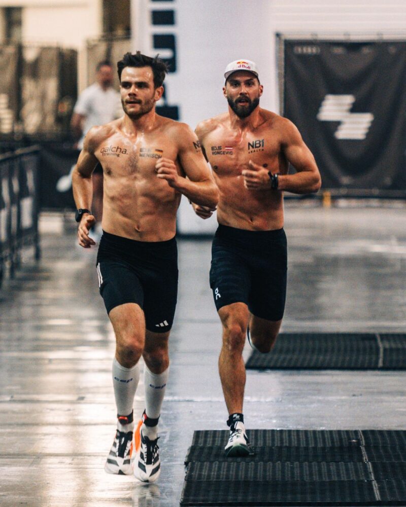 Alex Roncevic and Tim Wenisch running side by side on the HYROX race course during competition