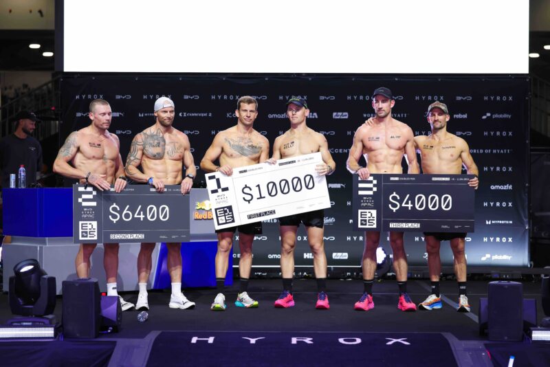 Elite Doubles Men’s podium at the 2026 HYROX Brisbane Major, with teams holding checks for first, second, and third place.