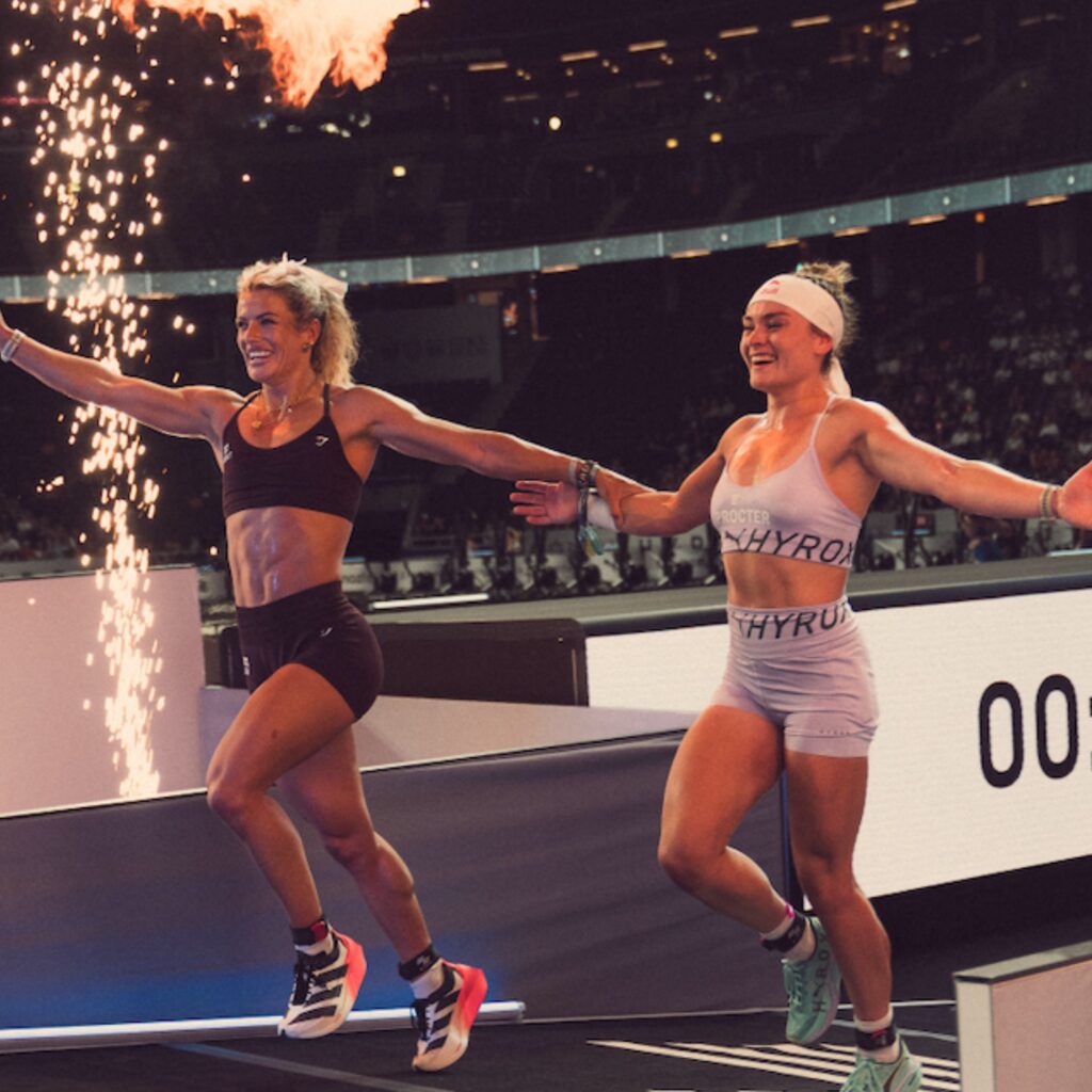 Sinead Bent and Lucy Proctor Elite Doubles athletes celebrate as they cross the finish line beneath pyrotechnics at the World Championships.